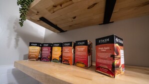 A wooden shelf with various boxes of Stash tea products. - Hamilton Hideaway  (Fortville)