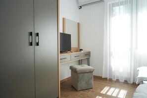 A bedroom with a bed, a desk with a computer, a mirror, and a wardrobe. - 2 Bed Apt - Sleeps 4, Terrace & Pet Friendly (Sandanski)