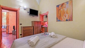 A hotel room with a bed, a television, a painting, and a bathroom visible through an open door. - La Perla, Walk to Casino & Old Town, Sanremo, Italy (Sanremo)