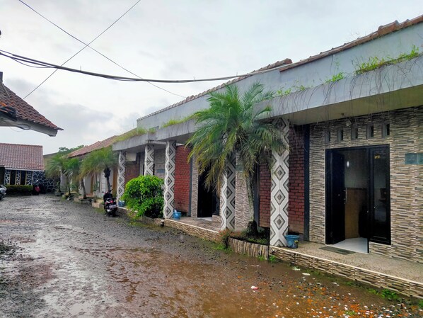 A row of buildings with a wet ground, possibly due to recent rain.