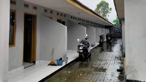 A corridor with tiled flooring and a narrow water channel. - Hotel Intan Niaga (Banjaran)