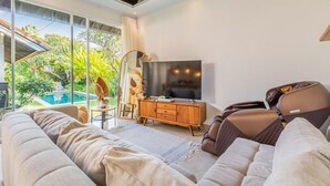Una sala de estar moderna con un sofá grande, un televisor y un mueble de madera.