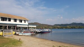 A lakeside building with a dock and boats.