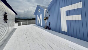A blue building with a large 'M' and 'E' on its side, a lifebuoy, and a net.