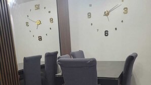 A room with a dining table and chairs, a clock on the wall, and a tiled floor. - Nice apartment in Cercado de Lima (Callao)