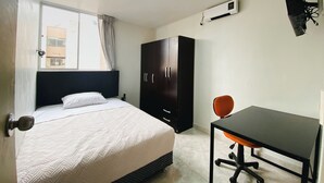 A bedroom with a bed, a wardrobe, a desk, and a chair. - Nice apartment in Cercado de Lima (Callao)