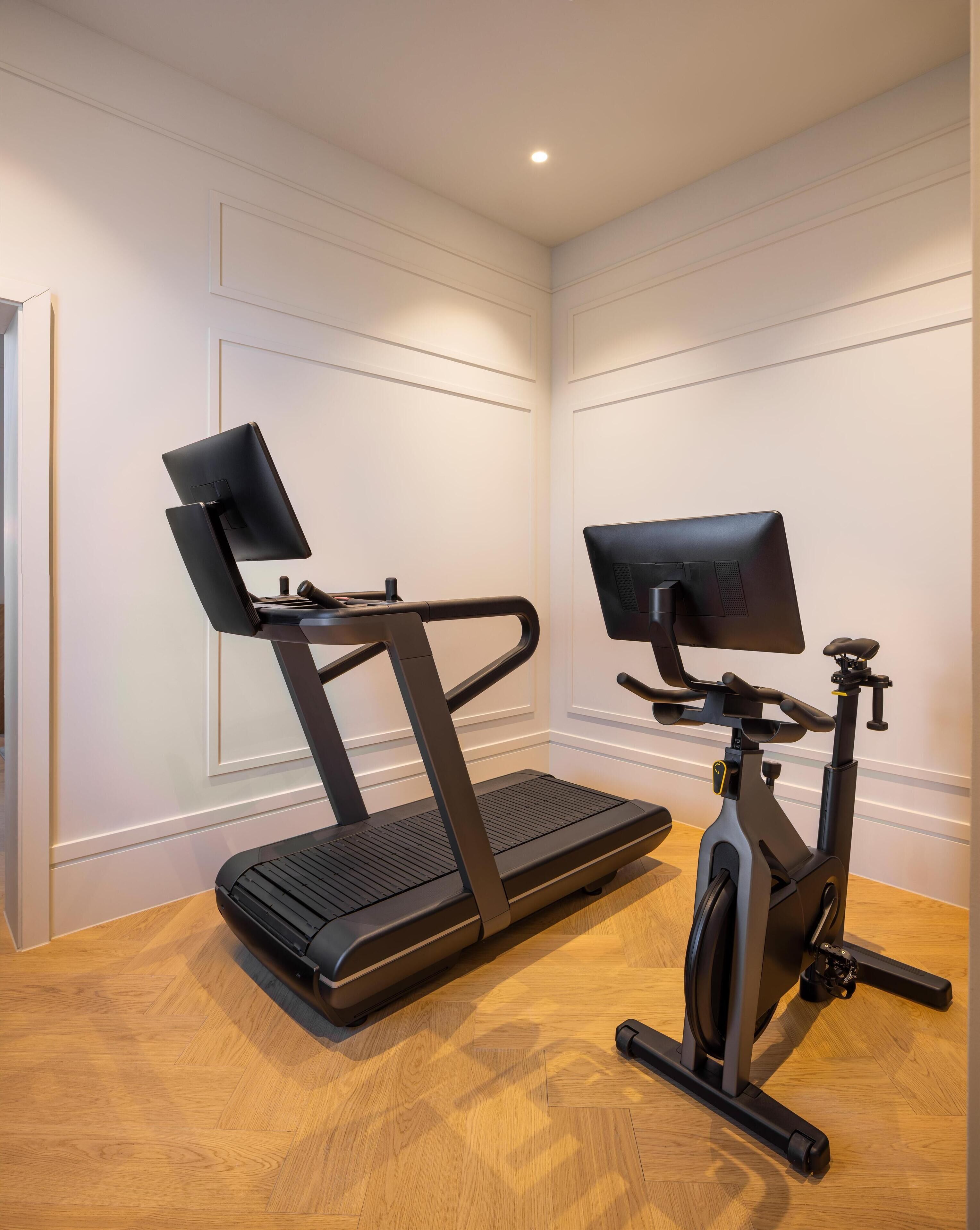Un gimnàs a casa amb una cinta de córrer i una bicicleta d'exercici.