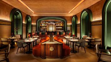 A luxurious dining area with a central bar, high-backed chairs, and a warm, inviting atmosphere.
