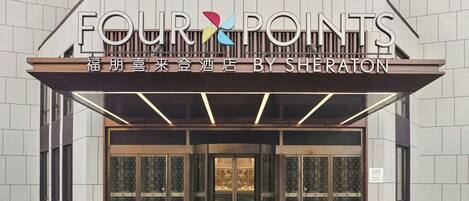 A hotel entrance with a sign reading "FOUR POINTS BY SHERATON".