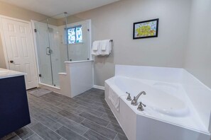 A modern bathroom with a glass-enclosed shower, a large bathtub, and a white sink. - 6S Hideout Houston (Houston)