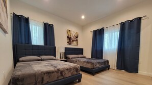 Un dormitorio con dos camas, una mesita de noche, una lámpara y un cuadro en la pared.