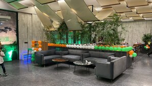 Una hall moderna con un divano componibile, un tavolino da caffè e una parete decorata con palloncini.