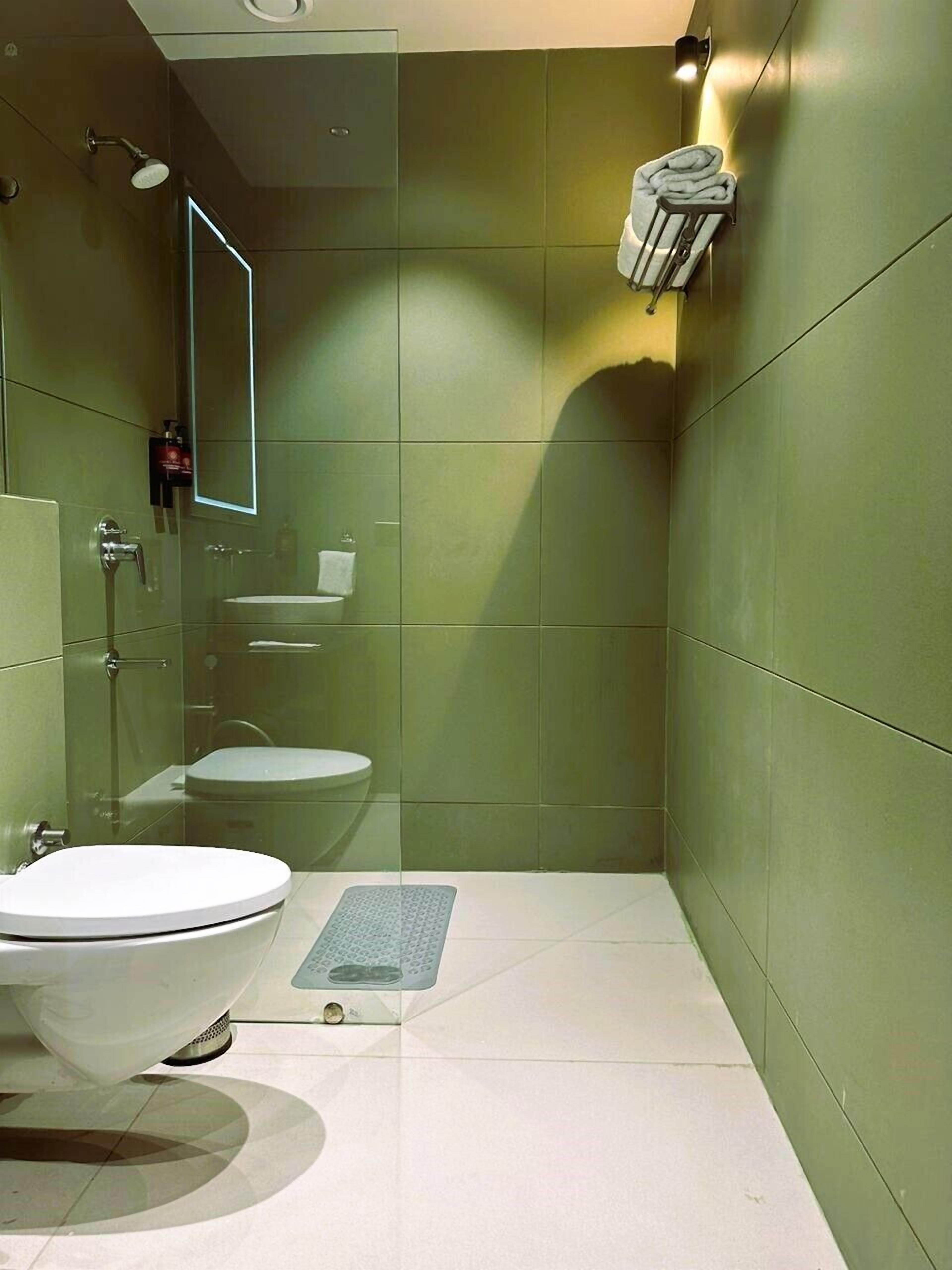 A modern bathroom with a toilet, bidet, and shower.