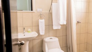 A bathroom with a sink, toilet, and shower curtain.