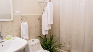A bathroom with a sink, toilet, and shower curtain.