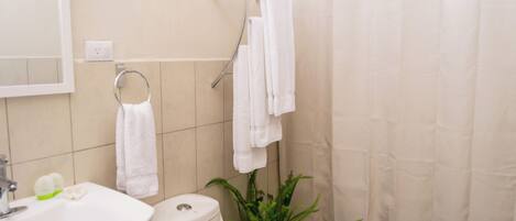 Un baño con lavabo, inodoro y cortina de ducha.