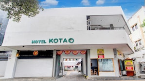 Ένα ξενοδοχείο με το όνομα HOTEL KOTAO, με κλειστή πόρτα γκαράζ, μια ευδιάκριτη είσοδο και μια πινακίδα που διαφημίζει μια τοπική επιχείρηση.