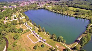 An aerial view of a lake surrounded by residential buildings and greenery.