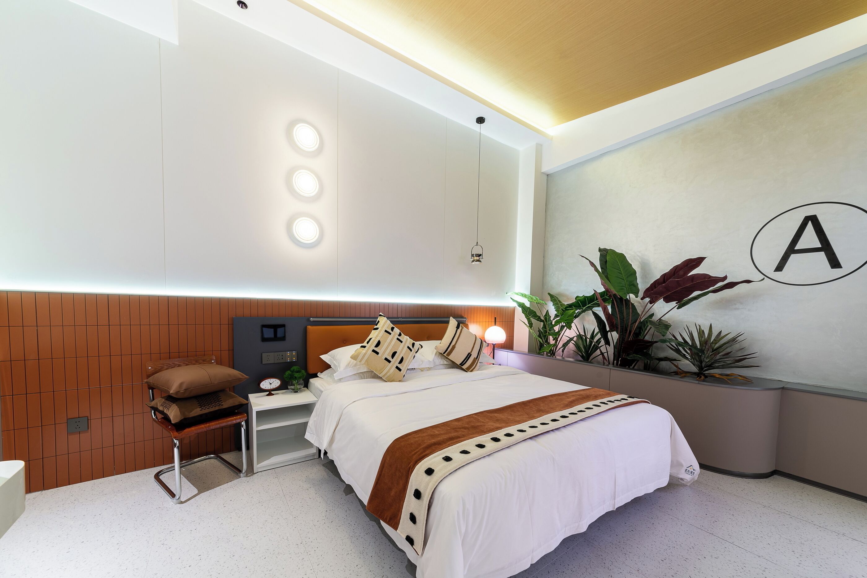 Un dormitorio moderno con cama, mesita de noche y una silla.