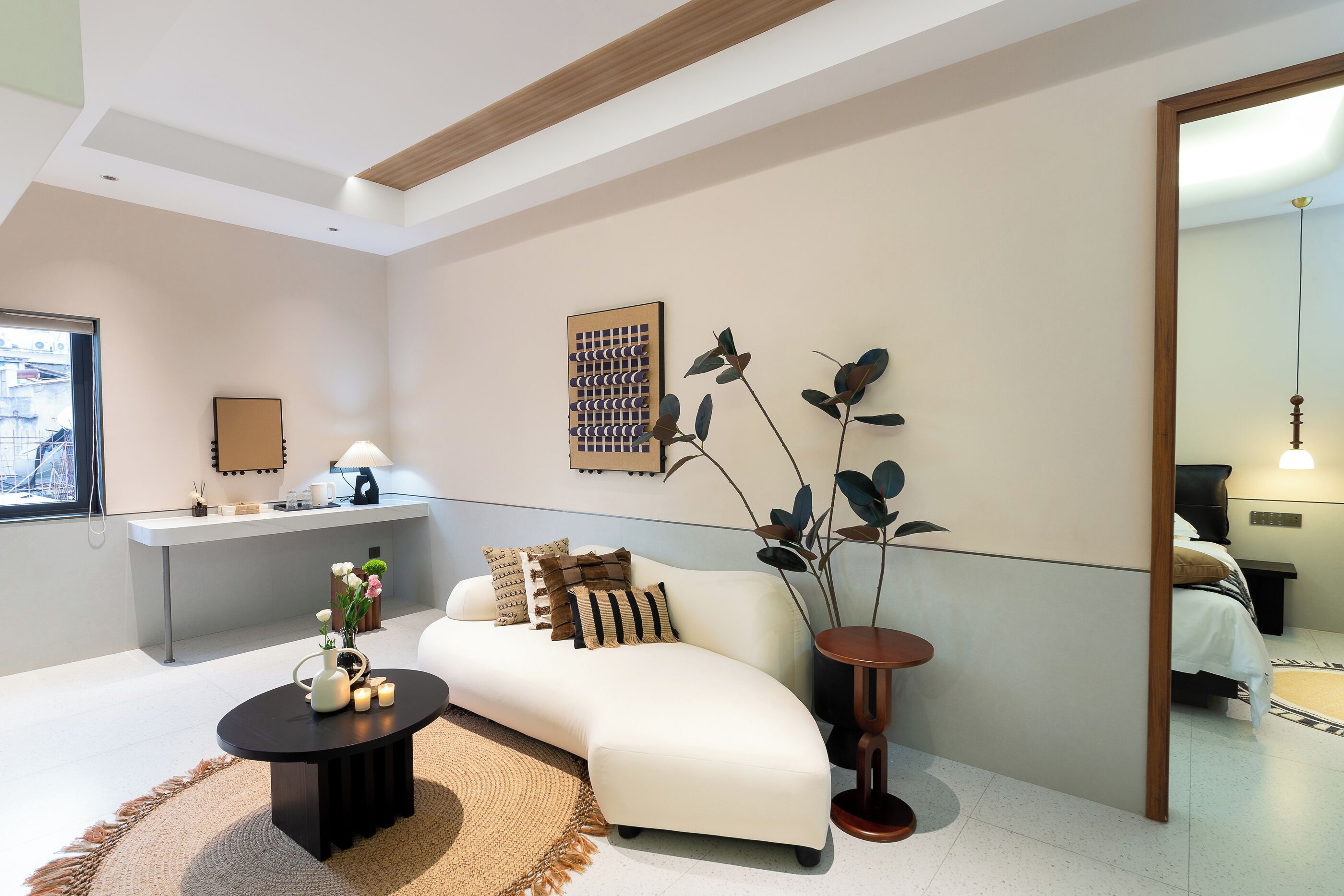Un salon moderne avec un canapé blanc, une table basse ronde et un grand miroir.