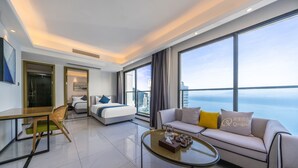 Una habitación de hotel moderna con cama, sofá y zona de comedor.