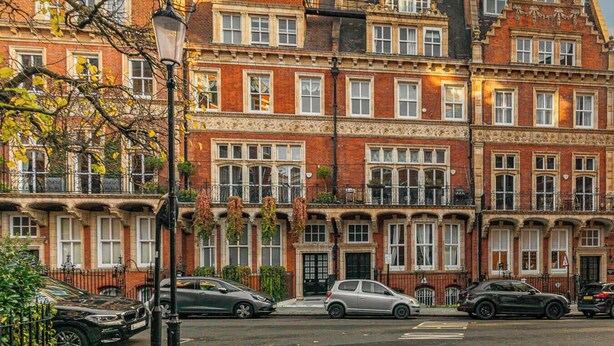 A row of red brick townhouses with multiple windows, a street lamp, and parked cars. - The Gallery - Exquisite Apartment, Kensington (Kensington)
