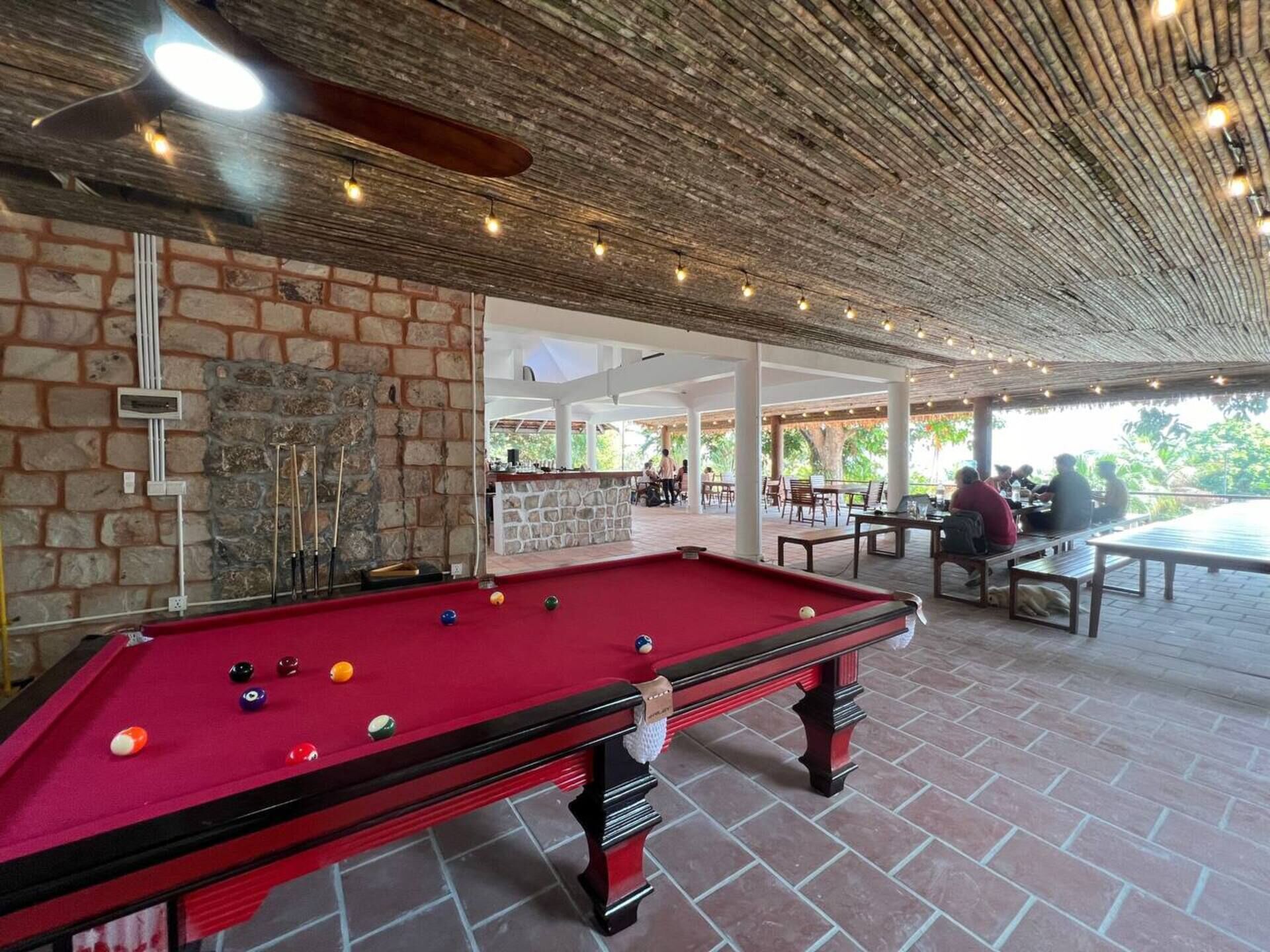 Une table de billard avec des billes, un mur de briques et un mur de pierres.