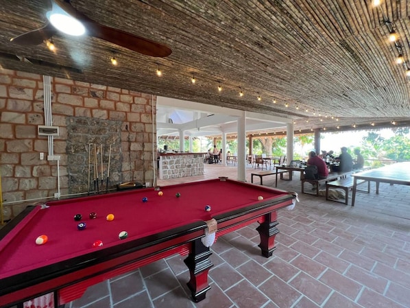 A pool table with balls, a brick wall, and a stone wall. - Mad Monkey Koh Sdach (Kiri Sakor)