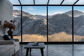 A modern interior with a large window offering a view of snow-covered mountains. - Thanks Hotel (Xinzhou)