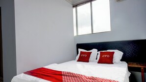 A hotel room with a bed, two red pillows with the word "OYO" on them, a white bedspread, and a red and white patterned blanket. - Hotel O Medan City Center Near Plaza Medan Fair Formerly Waringin Residence (Medan)