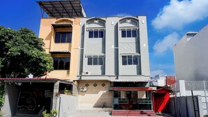 A multi-story building with a flat roof, a garage, and a storefront. - Hotel O Medan City Center Near Plaza Medan Fair Formerly Waringin Residence (Medan)