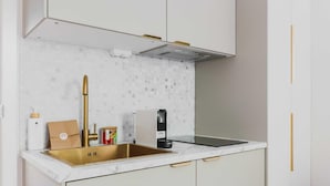 A modern kitchen with a stainless steel sink, white cabinets, and a marble backsplash. - Modern "green Suites" Residence - Meudon/valizy (Meudon)