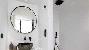 A bathroom with a round mirror, a stone sink, and a handheld showerhead. - Villa With Fantastic Terrace-sea Views (Mykonos)