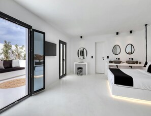 A modern bedroom with a large sliding glass door leading to a balcony, a central white bedside table, a double bed, and a built-in sink with two mirrors. - Villa With Fantastic Terrace-sea Views (Mykonos)