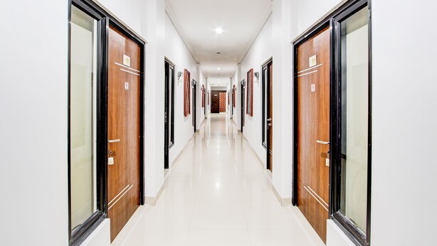 A long, narrow hallway with doors on both sides, leading to individual rooms.