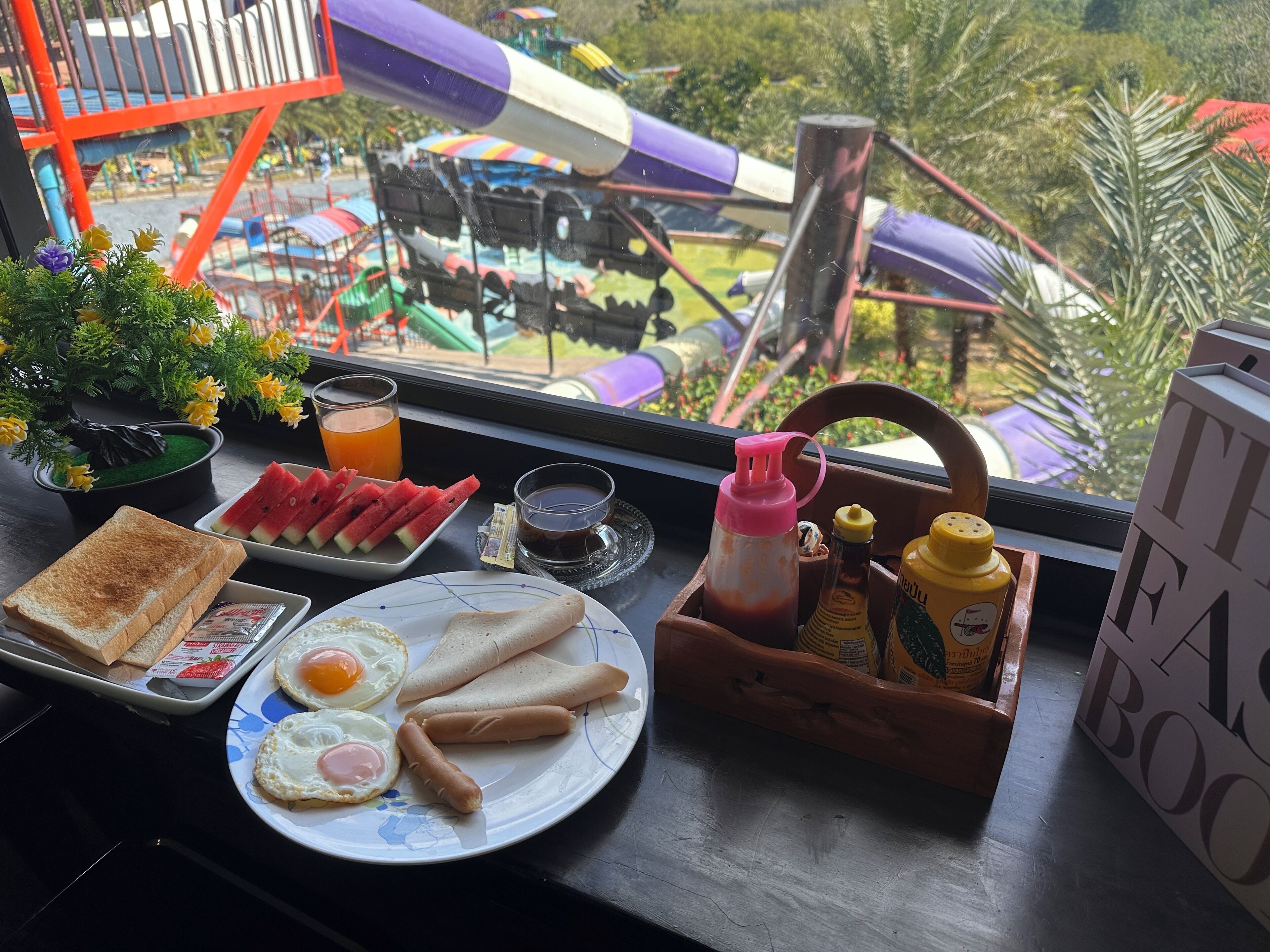 A breakfast table with toast, eggs, sausages, watermelon, and condiments.