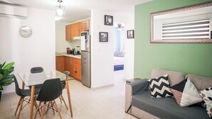 Um espaço compacto com área de refeições, cozinha compacta e sofá.