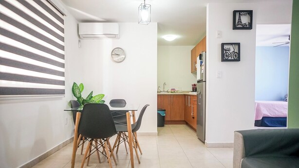 Um espaço compacto com área de jantar, cozinha compacta e cama.
