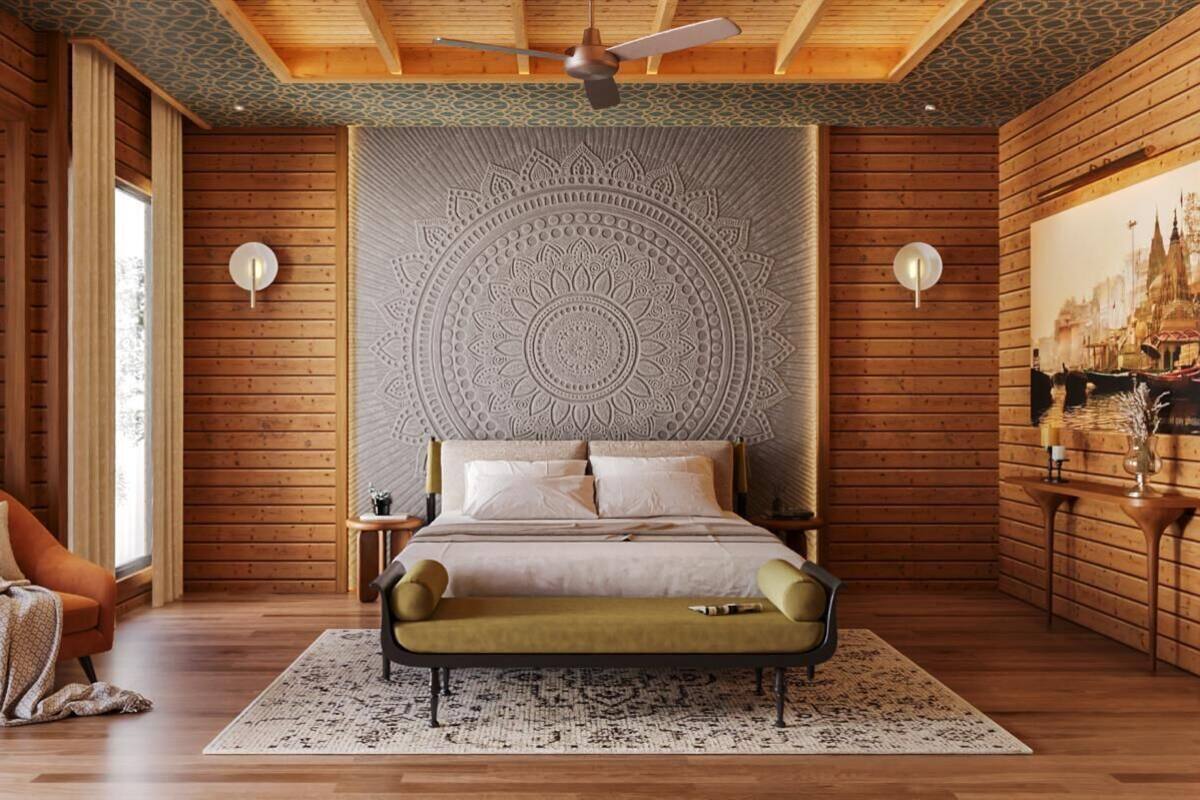 A bedroom with a large bed, a ceiling fan, and a wall with a decorative pattern.