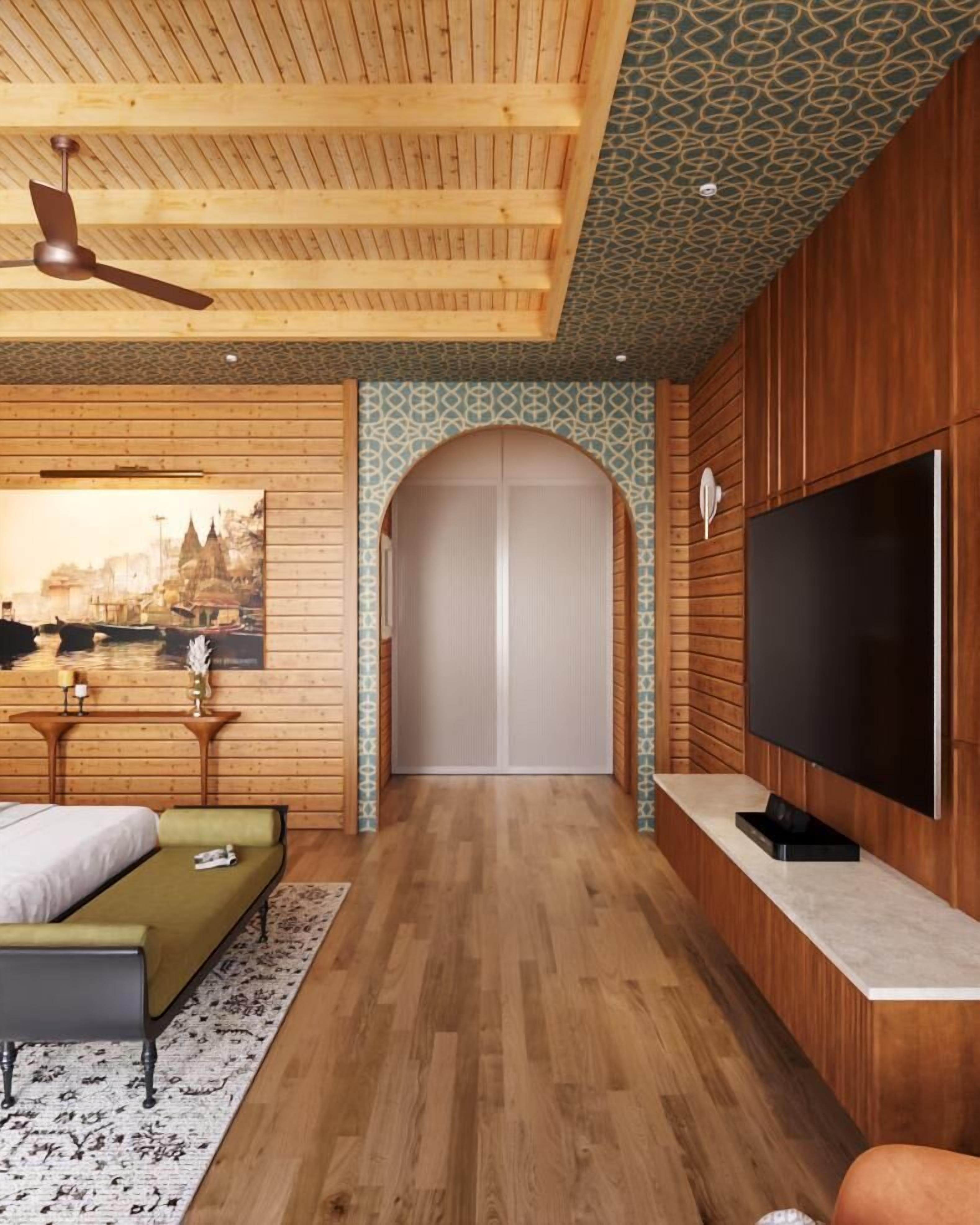 A modern hotel room with a wooden ceiling, a large flat-screen TV, a bed, a bench, and a decorative wall with a cityscape painting.