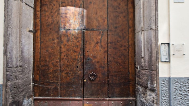 A large wooden door with a metal knocker, set in a stone archway. - Charming bedroom in Sorrento with balcony (Sorrento)