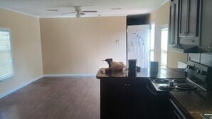 A spacious kitchen with wooden flooring, a ceiling fan, and built-in cabinets. - Reserve your very clean,quiet 3/2 mobile home in West San Antonio w/AC, WiFi (San Antonio)