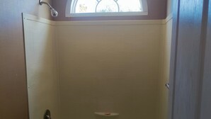 A bathroom with a bathtub, toilet, and a window above the tub. - Reserve your very clean,quiet 3/2 mobile home in West San Antonio w/AC, WiFi (San Antonio)