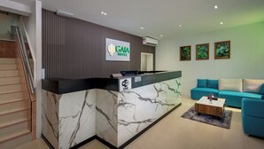 A hotel reception area with a marble counter, a Lenovo computer, a key drop station, and a Wi-Fi zone sign. - GAIA Hotel (George Town)