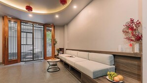 Ein modernes Interieur mit einer Couch, einem kleinen Tisch und einer Obstplatte.