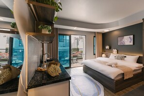 A modern hotel room with a large bed, a kitchen area, and a balcony with a view of the city. - My Home (Hanoi)