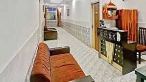 A hotel reception area with a reception desk, a clock, and a ceiling fan. - Hotel SkyView (New Delhi)