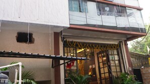 Un immeuble à plusieurs étages doté d’une façade moderne, avec de grandes fenêtres et un balcon aux étages supérieurs.