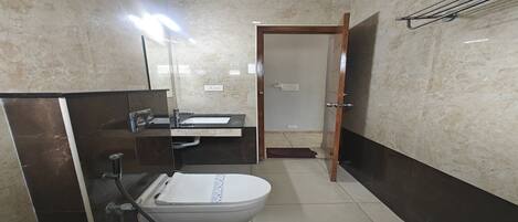 A bathroom with a toilet, sink, and mirror.
