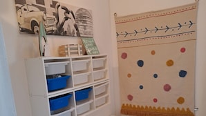 Una habitación con un mueble blanco para guardado, un banco y una pared con un diseño decorativo.